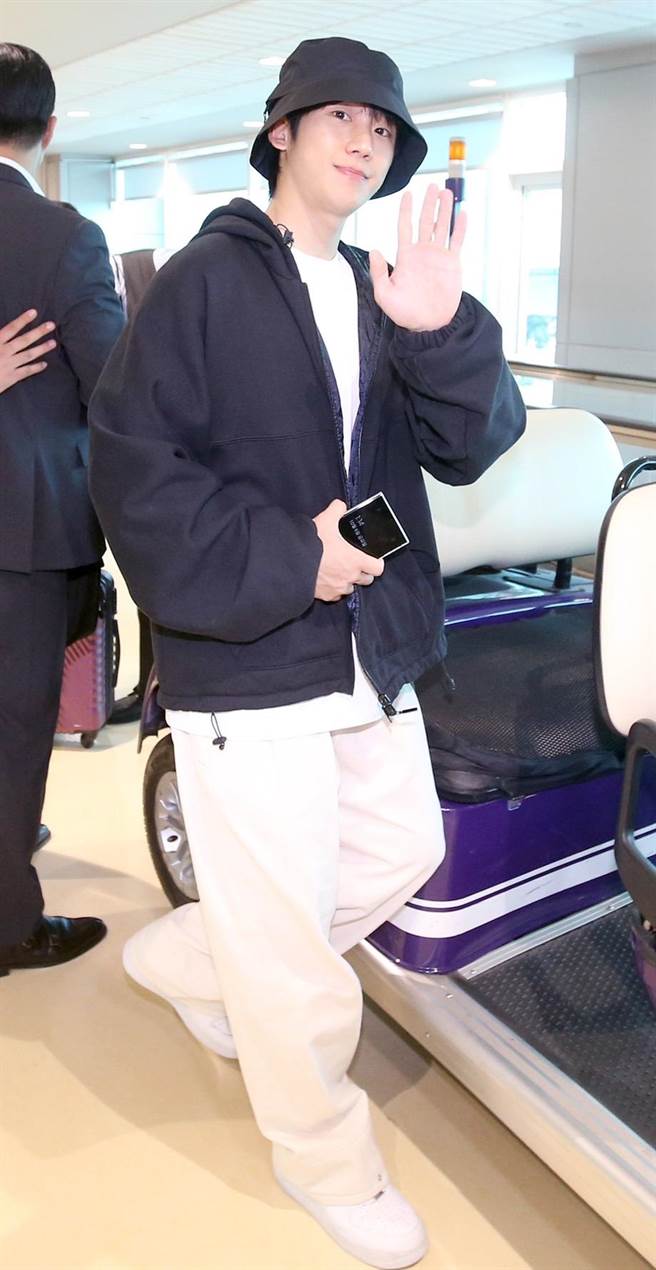 丁海寅下机后亲切地向同机旅客以及採访媒体挥手致意。（ 范扬光摄）