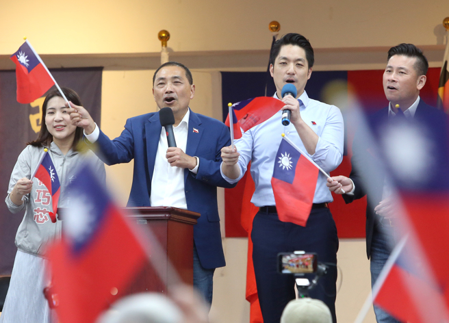 国民党总统参选人侯友宜（左二）和台北市长蒋万安（右二）6日一同出席台北市信义区西村里举办的112年国庆重阳晚会，两人手拿国旗高唱「中华民国颂」和大家庆祝国庆。（赵双杰摄）