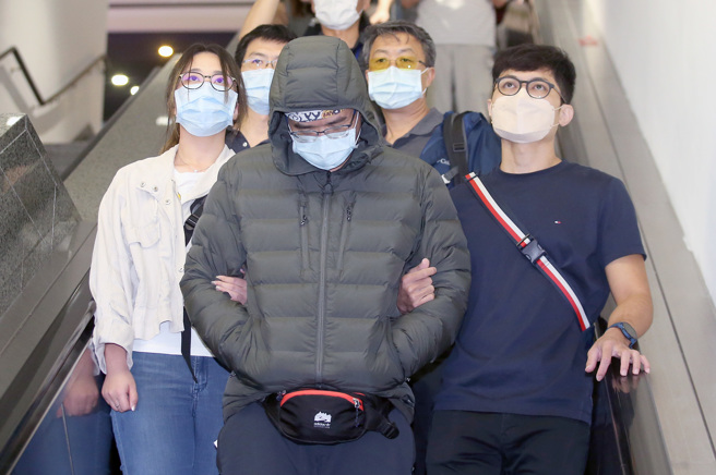 涉嫌自导自演遭人恐吓的「Lin bay好油」版主林裕纮（中）7日搭机返台，他下机后在员警陪同下前往桃园市刑大说明案情。（范扬光摄）