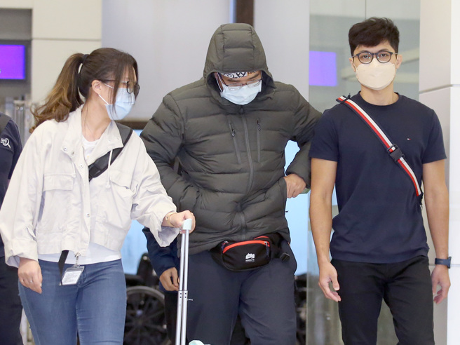 涉嫌自导自演遭人恐吓的「Lin bay好油」版主林裕纮（中）7日搭机返台，他下机后在员警陪同下前往桃园市刑大说明案情。（范扬光摄）