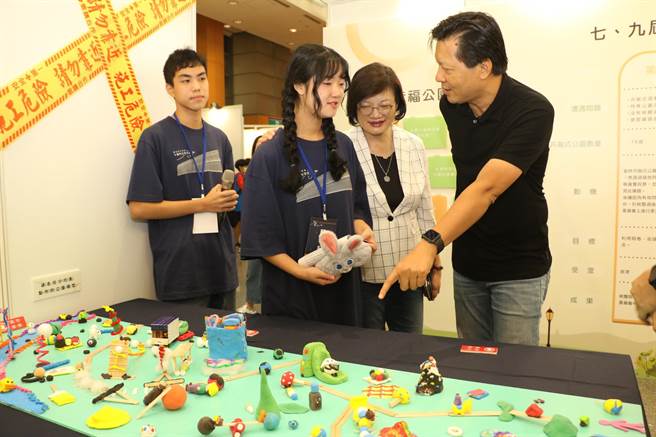 儿少代表顏彩妃（中）创作儿少代表卡通人物「阿培」，让副市长朱惕之（右）为之惊艳，建议可做成公仔。（新北市社会局提供）