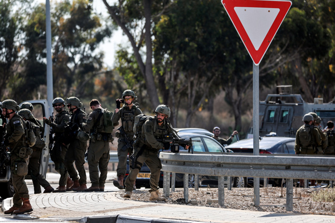 2023年10月7日，以色列军队聚集在以色列南部的一条道路上，火箭从斯德洛特郊外的加萨走廊发射。（路透社）