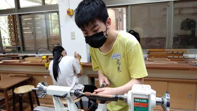 学生在汪永文悉心指导下，认真创作木工艺品。（新北市教育局提供）