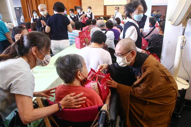 法鼓山紫云寺「家中宝」佛化联合祝寿活动于8日举行，活动进入尾声，法师们一一至座席间与老菩萨们献上关怀与祝福，并致赠伴手礼。（邓博仁摄）