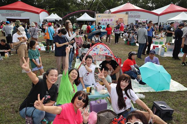 参加马拉桑千人午茶野餐趣活动的朋友穿上雨衣撑起小伞，开心度过一个彩虹罩顶的浪漫午茶约会。南投县政府提供