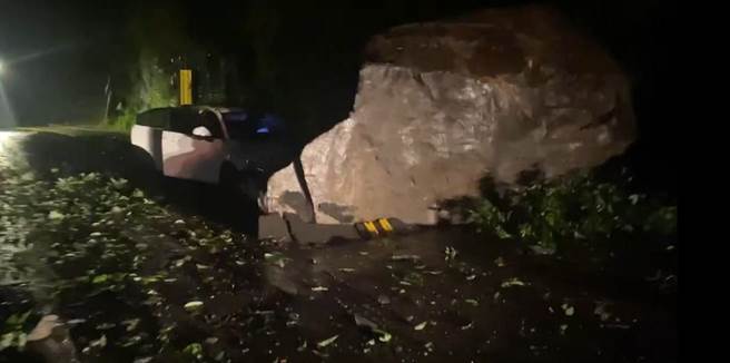 乌来区信贤里北107线3.30k，1块约6m＊6m＊6m巨石从坡地崩塌，砸中1部行驶中的轿车车头，车内1对年过70岁的夫妻仅受到惊吓，并无明显外伤。（新北市消防局提供）