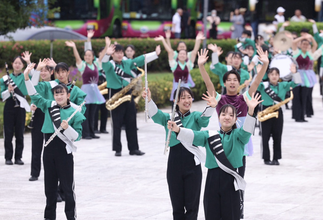 日本东京农业大学第二高等学校吹奏乐部今天上午于圆山大饭店前快闪演出，儘管天气不佳，仍不减民眾热情，还有来自日本的民眾组团在场外为学生们打气。（图／记者陈俊吉摄影）