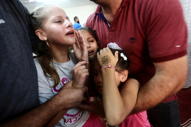 2023年10月7日，哈馬斯在加薩走廊北部對以色列發動突襲，巴勒斯坦小孩家哈馬斯武裝分子的葬禮時做出反應資料照。（路透社）