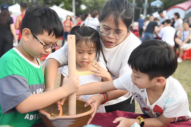 大小朋友一起將茶葉、芝麻與玄米等食材放進擂缽內以擂棒敲碎，沖成擂茶，體驗客家特有的擂茶文化。南投縣政府提供