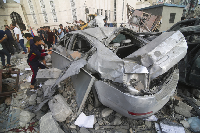 居加薩走廊南部城市甘尤尼斯遭到以色列猛力空襲，巴勒斯坦人的建物車輛嚴重毀損。（路透）