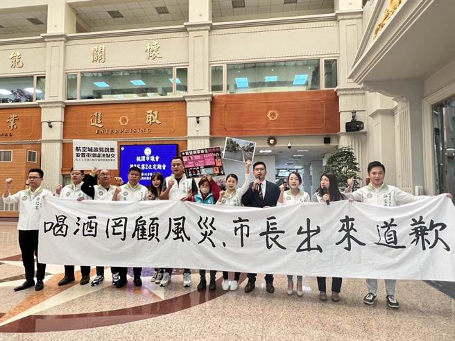 桃园市议会民进党团在市长张善政施政报告前「下马威」，会议开始前就在议会大厅拉白布条抗议「喝酒罔顾风灾，市长出来道歉」。（蔡依珍摄）