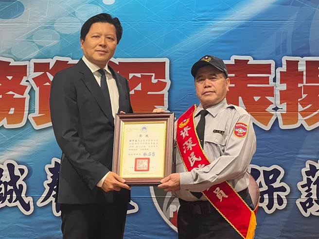 新北市副市長朱惕之（左）頒獎表揚服務年滿20年資深民防人員。（王揚傑攝）
