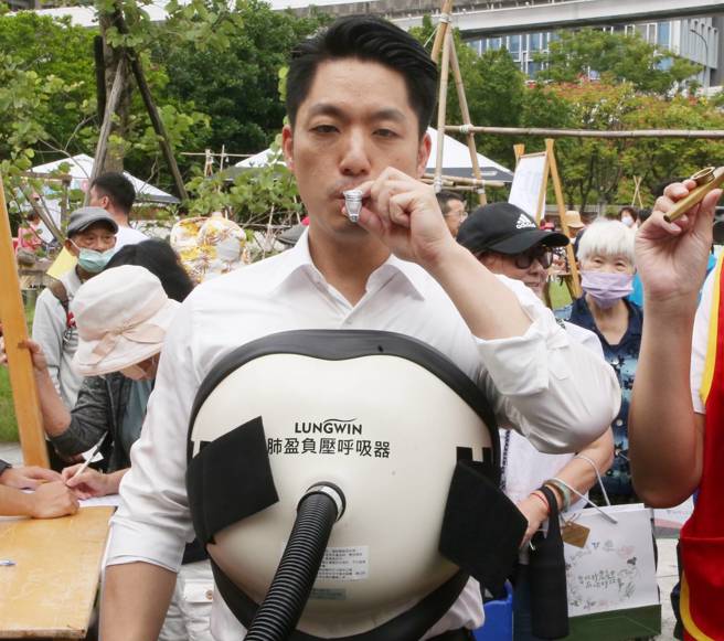 台北市长蒋万安（前）14日出席台北市东区社福园区举行的「再一次好好生活市集」重阳节系列活动，体验如何用呼吸器训练呼吸。（赵双杰摄）