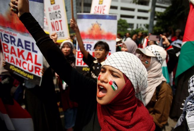 马来西亚民眾13日在首都吉隆坡发起游行，以行动支持巴勒斯坦人。（路透）