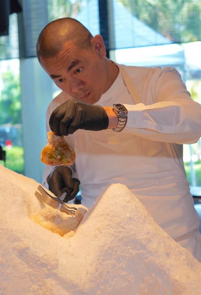 江振诚在现场敲出盐焗后的料理「用盐带出甜」。（何书青摄）