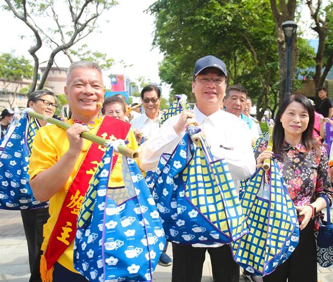 新北市代理市長劉和然（圖中）和值年爐主邱光彥（左一）、客家事務局長林素琴（右一）一起挑擔奉飯。（新北市客家局提供／柯毓庭新北傳真）