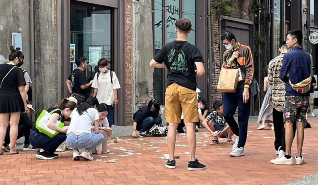 驳二特区昨15日下午惊传有人于大庭广眾撒下大量1元美金纸钞，由于纸钞看上去十分逼真，路过民眾见此一幕，已按捺不住急切的心情一拥将美金揽入怀中。（图 / 翻摄自爆料公社）