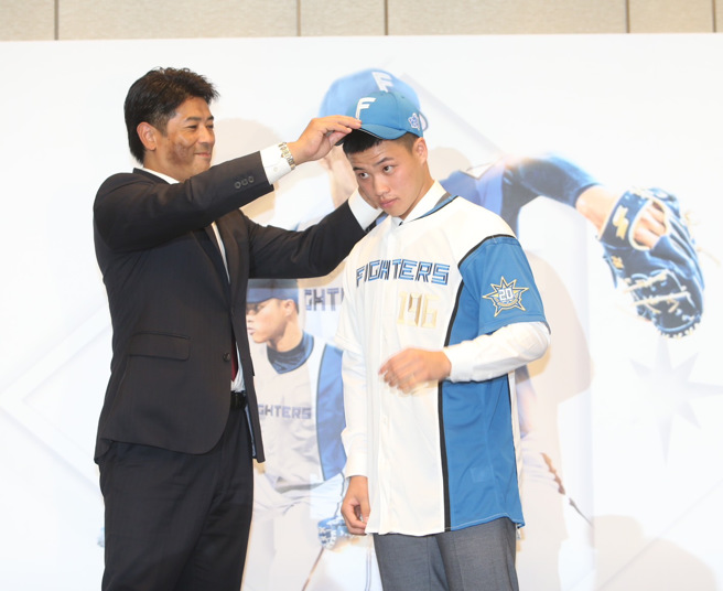 日职火腿队总经理稻叶笃纪（左）为孙易磊戴上球帽。（陈怡诚摄）