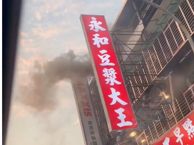 永和豆浆店的排烟管起火燃烧，公寓４楼冒出浓烟。民眾提供