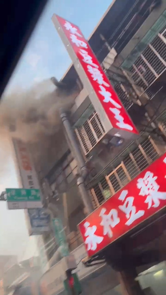 永和豆浆店的排烟管起火燃烧，公寓４楼冒出浓烟。民眾提供