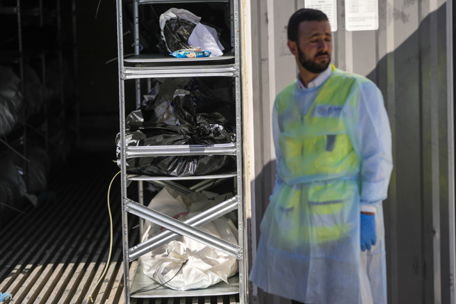 舒拉基地的部分验尸工作今天对媒体公开。当货柜门打开时，强烈的气味让人不得不戴上口罩。（图/美联社）
