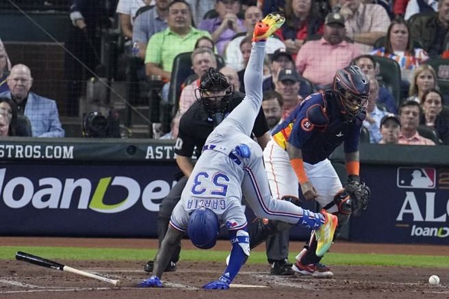 游骑兵贾西亚挨了触身球，紧急侧翻稳住身体平衡。（美联社）