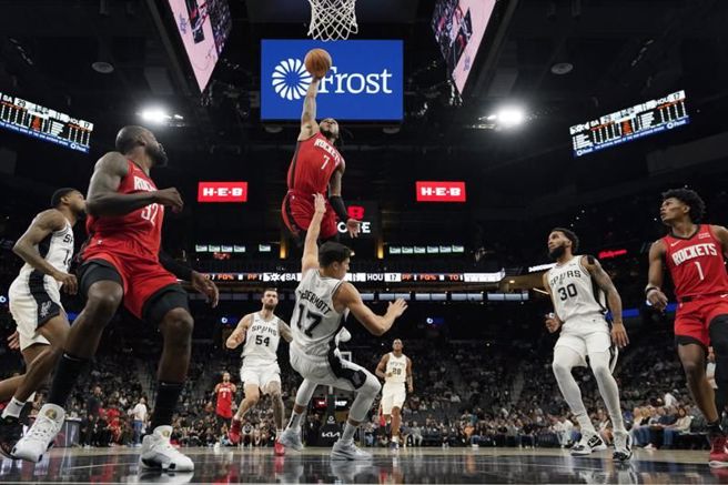 火箭新秀惠特摩(中)飞身灌篮，撞倒马刺前锋麦德莫特，被吹进攻犯规。（美联社）