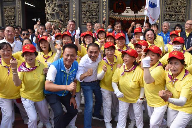 侯友宜17日下午赴苗栗县头份市义民庙参拜，喜遇10年一大巡的苗栗城隍爷出巡，与立委参选人苗栗市长邱镇军一同与婆婆妈妈合照。（谢明俊摄）