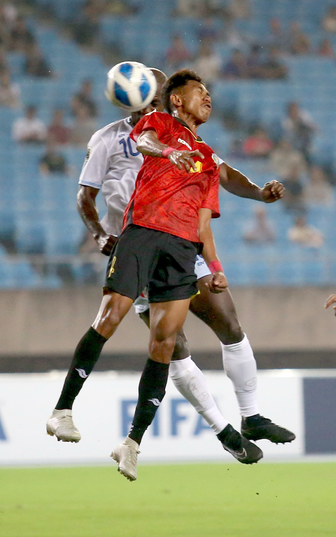 中华男足前锋安以恩（后）力压对手后卫头槌破门。（李弘斌摄）