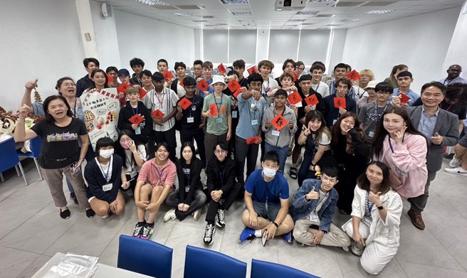 醒吾科大應英系主任張煜權(右後)及老師、學生們與City of London School學生合影，學生們紛紛拿出春聯開心合照。(醒吾科大提供)