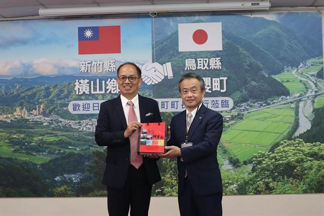 日本鸟取县若樱町长上川元张（右）18日率团来访新竹县横山乡，乡长张志弘送上在地特产相见欢，双方并提出教育交流计画。（邱立雅摄）