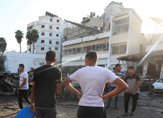 加萨阿赫利阿拉伯医院（Al Ahli Arab hospital）遭空袭后，当地居民18日检视现场的画面。（路透）