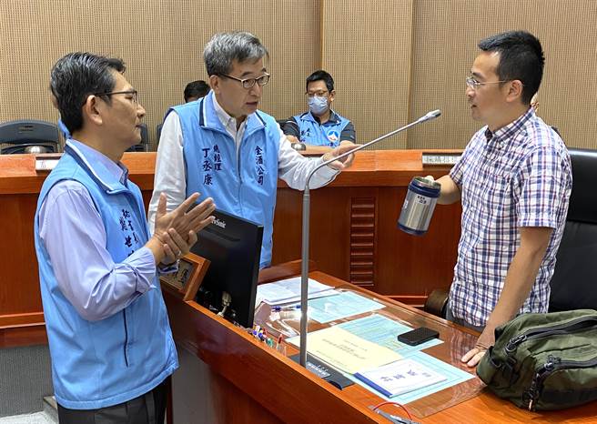 议会质询结束后，金酒总经理丁丞康(中)与议员董森堡讨论相关法令与作业细节。(于家麒摄)