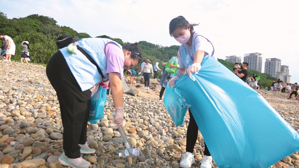 同學仔細將卡在沙地裡面的廢棄垃圾挖掘出來，恢復沙灘乾淨環境。(照片/聖約翰科技大學提供)