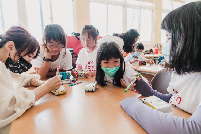 「微距种子博物馆」设计师谢沛宸(左一)带领孩童们将採集风景及心得绘制于白色的机身。（图片来源：高雄市文化局提供）