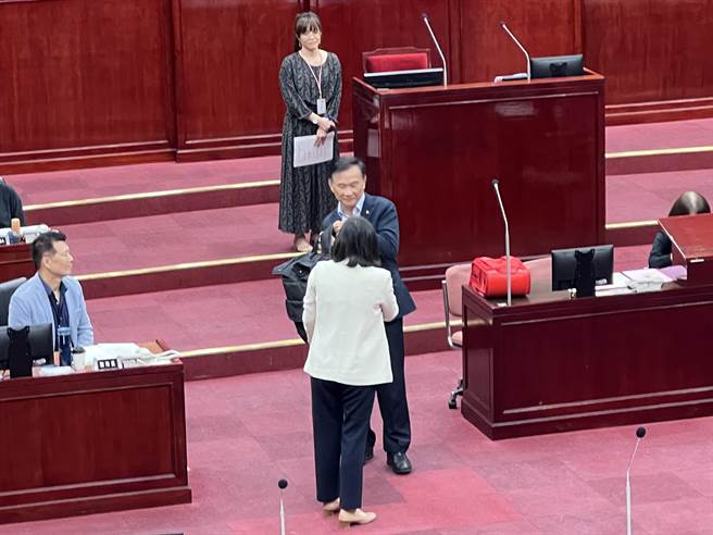 民进党台北市议员何孟桦指出，中年级学生书包最重将近14公斤，并拿出相当重量书包邀请教育局长汤志民试背，不过汤笑着摇头表示没办法。（蔡宗颖摄）