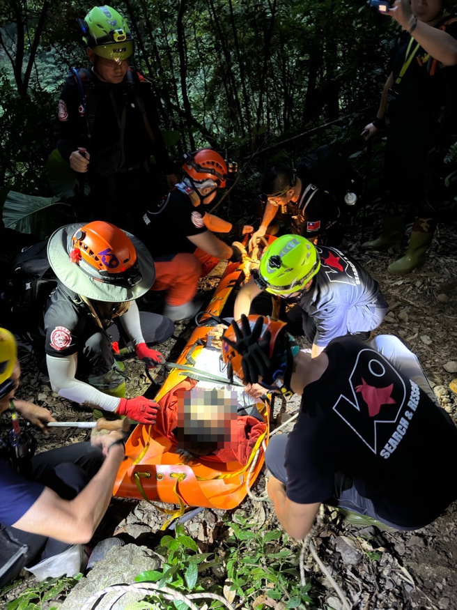 消防隊員協助將婦人運送下山送醫。（黃仲瑜翻攝）