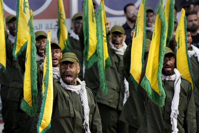 伊朗国营电视台节目警告，以色列恐面临包括黎巴嫩真主党（Hezbollah）、叶门青年运动等组织从南方、东方、北方的联合攻击。图为真主党民兵10日参加同袍葬礼时高喊口号。（图／美联社）