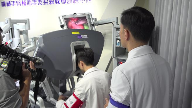 同学们对于在高医大校园就能实地体验操作达文西手臂都感到十分幸福。（图片来源：记者 赖君欣 摄）