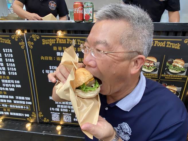 金沙镇长吴有家对于美食也无法抗拒，现场嗑起美式汉堡大声称讚，欢迎乡亲一起来尝鲜。(于家麒摄)