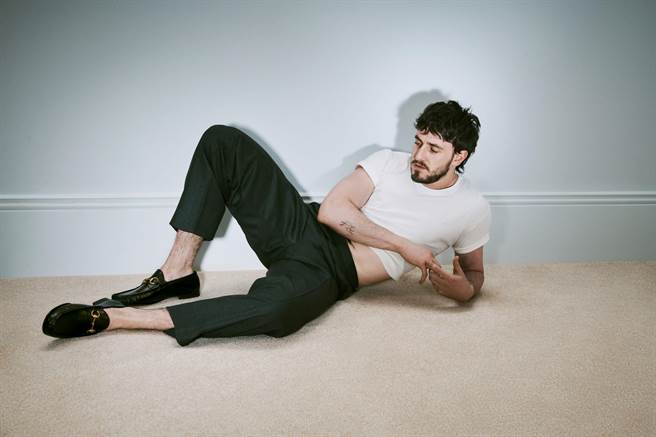 曾入圍奧斯卡影帝的保羅·麥斯卡以短褲、風衣搭配樂福鞋，愜意休閒的躺在沙發上當「沙發馬鈴薯」。（GUCCI 提供／林欣儀台北傳真） 