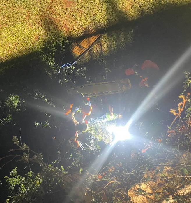 消防人員展開救援，架梯並利用繩索下到溝底將摔落的女子救起。（翻攝畫面）