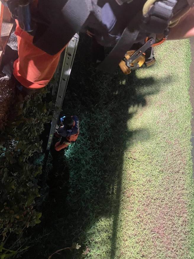 消防人員展開救援，架梯並利用繩索下到溝底將摔落的女子救起。（翻攝畫面）