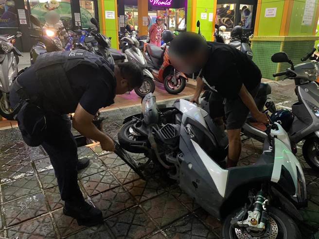 22日深夜周男KTV歡唱散場後，發現機車卡死在水溝蓋，只好報警求救，與警方合力放倒機車後才成功脫困。（警方提供／任義宇高雄傳真）