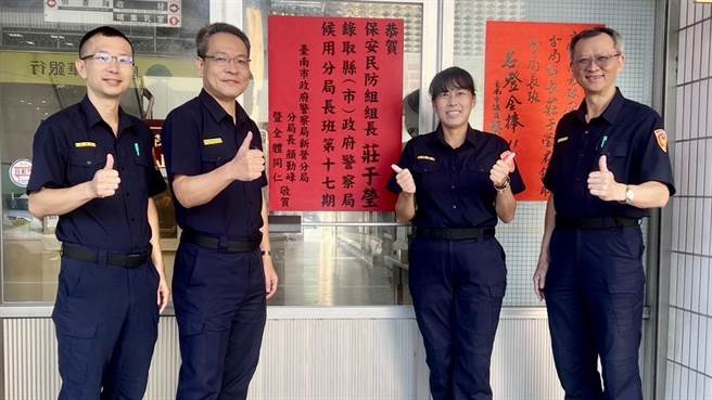 台南市警察局新营分局再揭红榜，保安民防组组长庄于莹（右二）录取候用分局长，新营分局长顏勤峰（左二）贴红榜祝贺。（新营警分局提供／张毓翎台南传真）