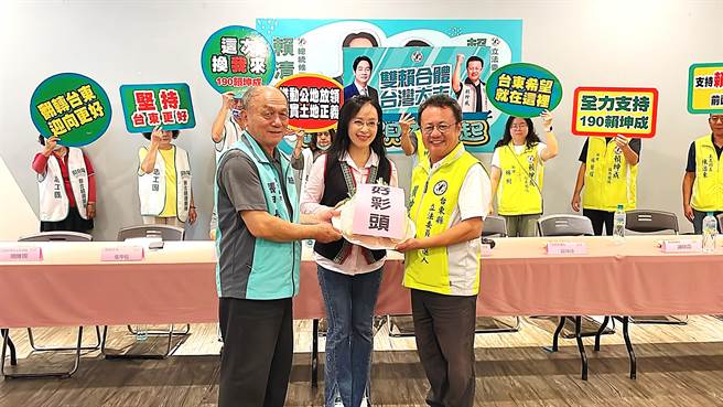 民进党台东县总统立委联合竞选总部主委张甲长（左）送上菜头给台东区域立委参选人赖坤成（右），喻意选情有好彩头。（萧嘉蕙摄）