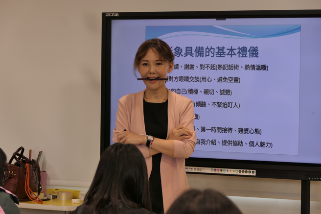 詹琇芳示範半月型最迷人的上排8顆牙齒笑容，同學們個個嘖嘖稱奇。(戴志揚翻攝)