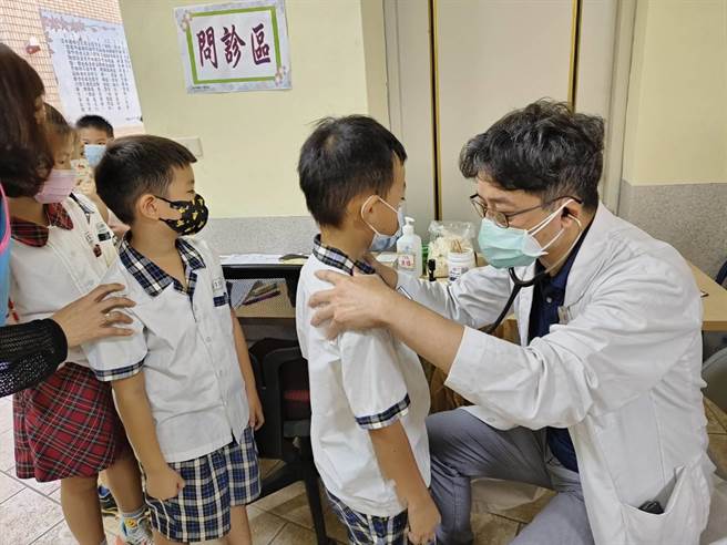 嘉義市慶昇醫院副院長黃仕達到博愛國小為小朋友接種流感疫苗問診。（廖素慧攝）
