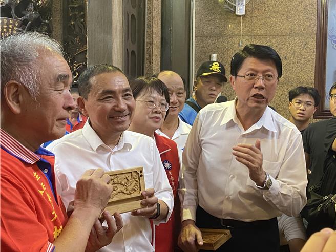 開基玉皇宮贈送國民黨總統參選人侯友宜（左二）「和平鴿」肖楠木雕作品。（曹婷婷攝）