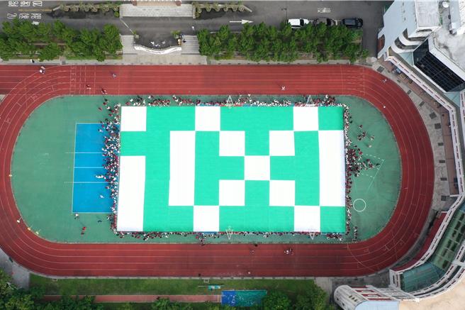 基隆女中24日上午在学校的操场排出绿底白字的「i∞」字样，为明年4月的百年校庆暖寿。（国立基隆女中提供／张志康基隆传真）